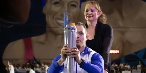 Atleta enciende el pebetero de la justa deportiva.